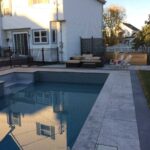 Fiberglass pool installation in residential backyard with modern landscaping