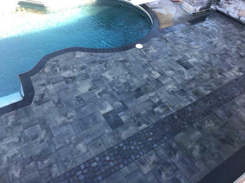 Custom fiberglass pool installation with patio and landscape design